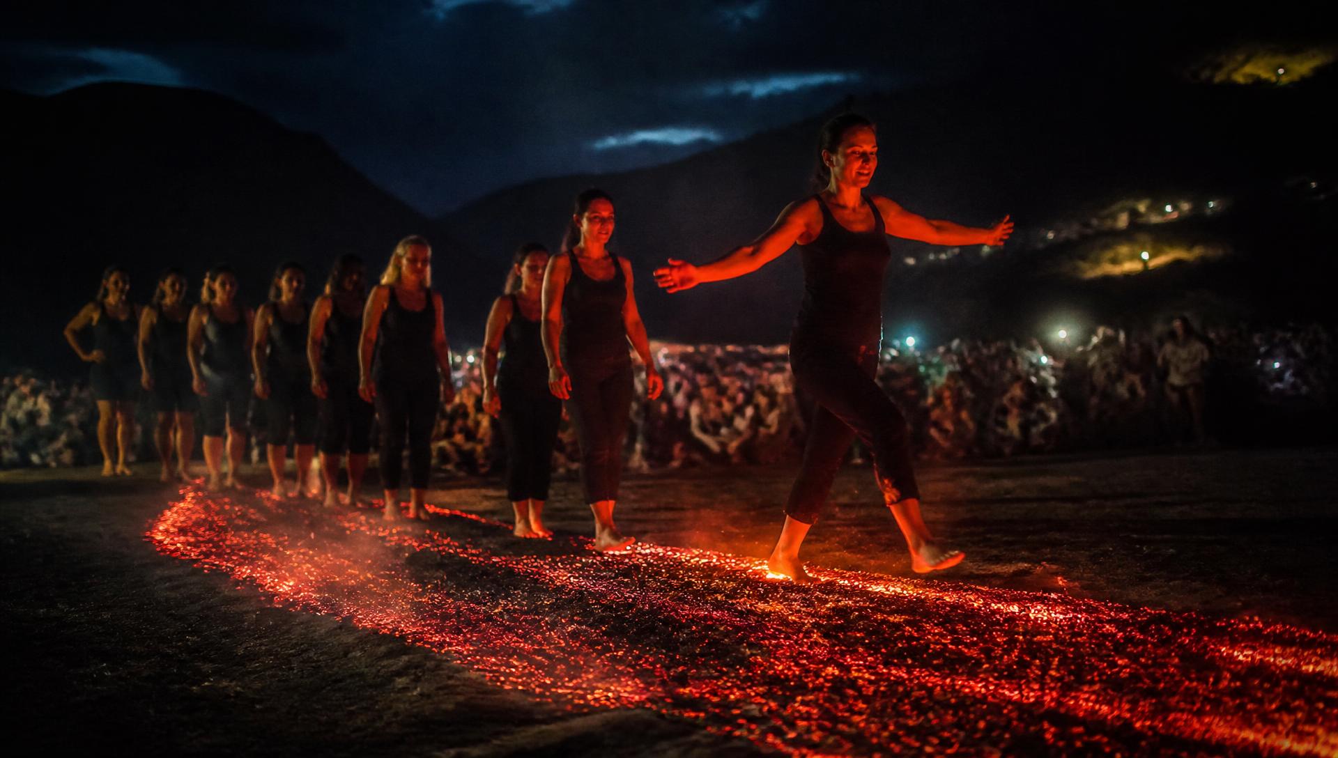 Mulheres atravessando a esteira de fogo à noite